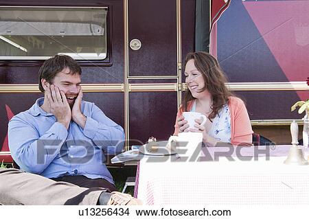 Couple picnicking outside trailer View Large Photo Image Picture - Couple picnicking outside trailer. Fotosearch