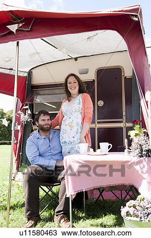 Couple picnicking outside trailer View Large Photo Image Stock Image - Couple picnicking outside trailer. Fotosearch