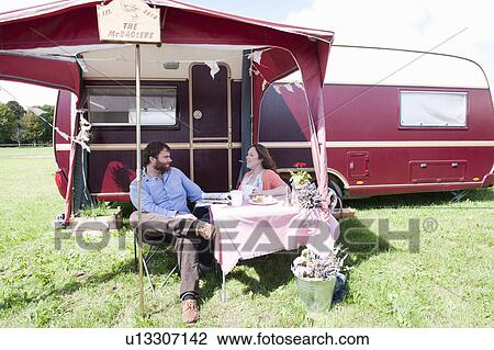 Couple picnicking outside trailer View Large Photo Image Stock Image - Couple picnicking outside trailer. Fotosearch