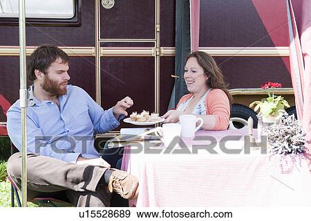 Couple picnicking outside trailer View Large Photo Image Stock Photo - Couple picnicking outside trailer. Fotosearch