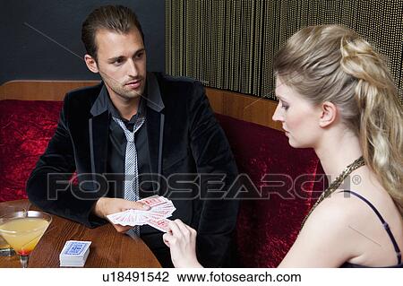 Stock Image - Couple playing cards in bar. Fotosearch