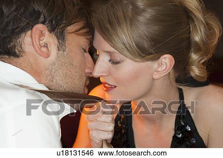 Stock Photograph - Couple touching noses in restaurant. Fotosearch