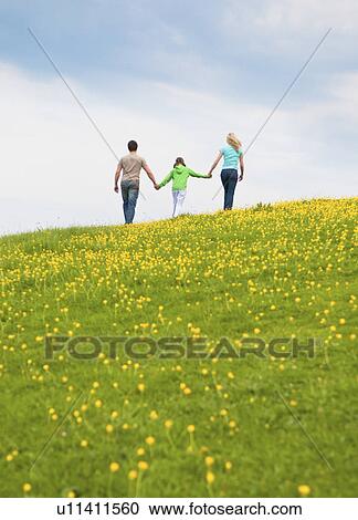 Stock Image - Family walking and holding hands. Fotosearch