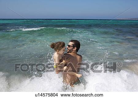 Father and daughter playing in waves View Large Photo Image Picture - Father and daughter playing in waves. Fotosearch