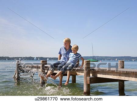 Father and son dangling feet in lake View Large Photo Image Stock Image - Father and son dangling feet in lake. Fotosearch