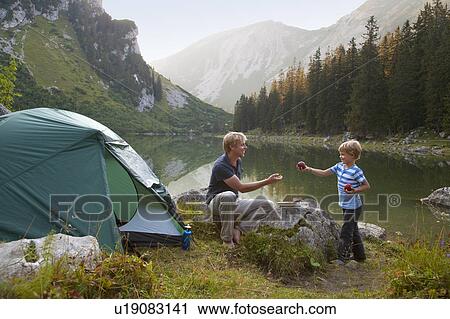 Father and son eating at campsite View Large Photo Image Stock Image - Father and son eating at campsite. Fotosearch