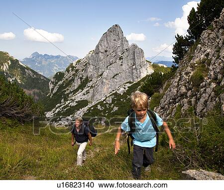 Stock Image - Father and son hiking on mountain path. Fotosearch