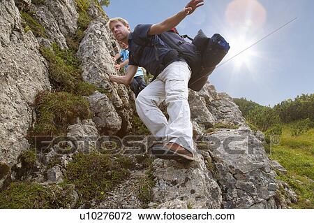 Stock Image - Father and son hiking on rocky terrain. Fotosearch