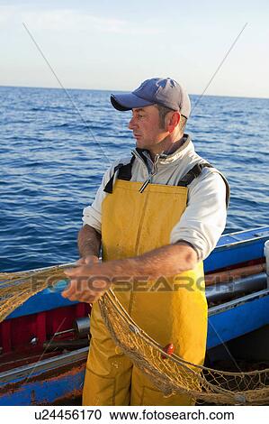 Fisherman pulling in nets on boat View Large Photo Image Stock Image - Fisherman pulling in nets on boat. Fotosearch
