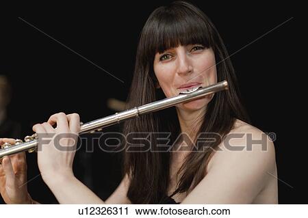 Stock Image - Flute player in orchestra. Fotosearch