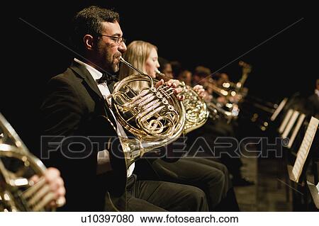 Stock Image - French horn players in orchestra. Fotosearch