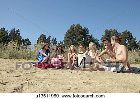 Friends having picnic on beach View Large Photo Image Stock Image - Friends having picnic on beach. Fotosearch