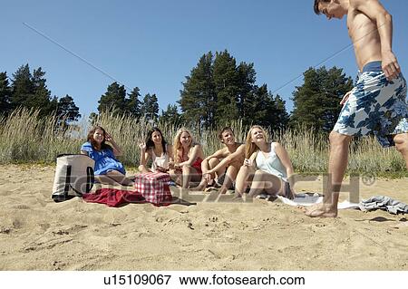 Friends having picnic on beach View Large Photo Image Stock Photo - Friends having picnic on beach. Fotosearch