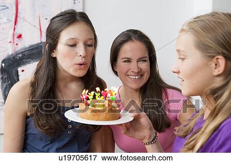 Stock Photo - Girl blowing out birthday candles. Fotosearch