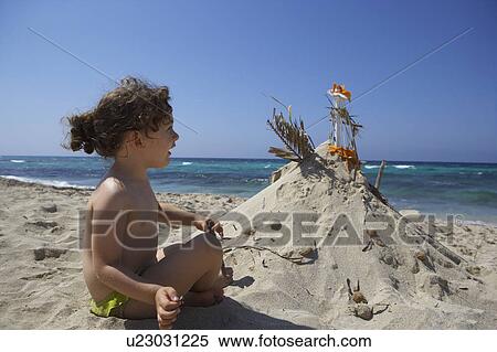 Girl building sandcastle on beach View Large Photo Image Stock Photography - Girl building sandcastle on beach. Fotosearch