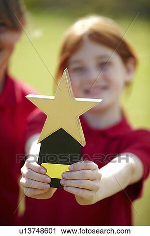 Girl cheering with trophy outdoors View Large Photo Image Stock Image - Girl cheering with trophy outdoors. Fotosearch