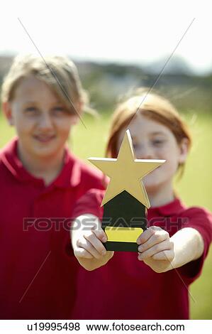Girl cheering with trophy outdoors View Large Photo Image Stock Photo - Girl cheering with trophy outdoors. Fotosearch