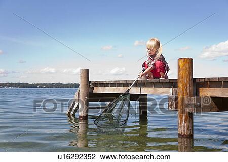 Girl fishing with net in lake View Large Photo Image Stock Image - Girl fishing with net in lake. Fotosearch