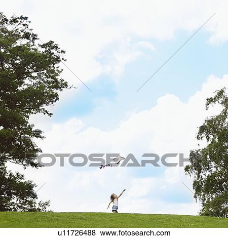 Girl flying kite in field View Large Photo Image Stock Photo - Girl flying kite in field. Fotosearch
