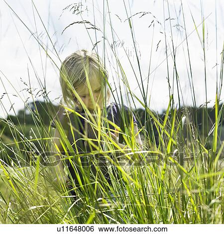 Girl hiding behind tall grass View Large Photo Image Stock Photograph - Girl hiding behind tall grass. Fotosearch