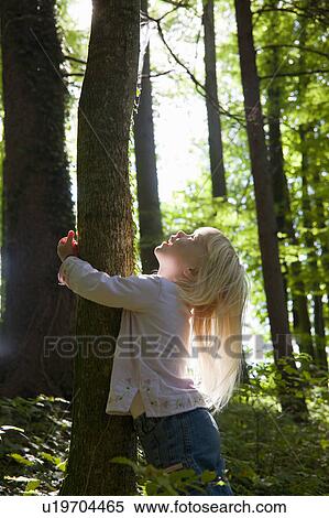 Girl hugging tree in forest View Large Photo Image Stock Photography - Girl hugging tree in forest. Fotosearch