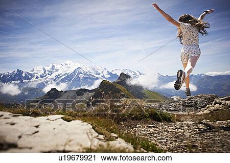 Girl jumping in rocky landscape View Large Photo Image Stock Image - Girl jumping in rocky landscape. Fotosearch