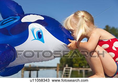 Girl kissing inflatable whale on dock View Large Photo Image Stock Image - Girl kissing inflatable whale on dock. Fotosearch