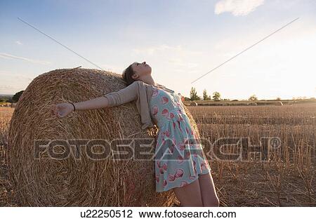 Girl leaning on haystack in field View Large Photo Image Stock Image - Girl leaning on haystack in field. Fotosearch