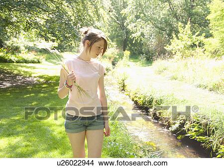 Girl picking flowers by river View Large Photo Image Picture - Girl picking flowers by river. Fotosearch