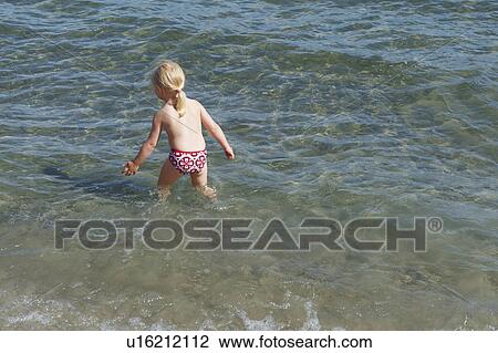 Girl playing in waves on beach View Large Photo Image Stock Image - Girl playing in waves on beach. Fotosearch