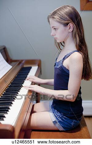 Girl practicing piano indoors View Large Photo Image Stock Image - Girl practicing piano indoors. Fotosearch