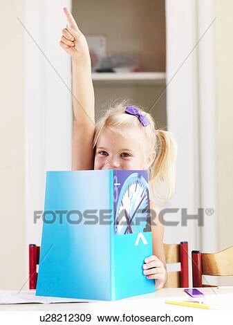 Stock Photo - Girl reading book at desk. Fotosearch