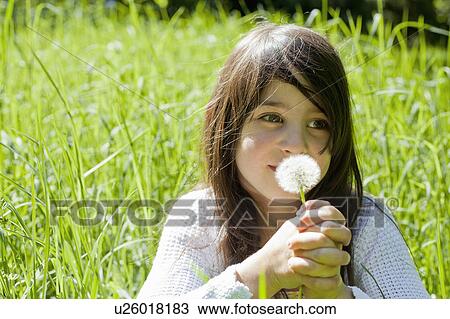 Girl smelling dandelion in tall grass View Large Photo Image Stock Image - Girl smelling dandelion in tall grass. Fotosearch