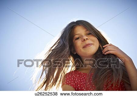 Girl smiling against blue sky View Large Photo Image Stock Photo - Girl smiling against blue sky. Fotosearch