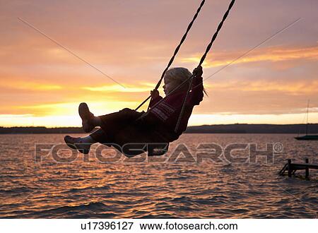 Girl swinging by lake View Large Photo Image Stock Photo - Girl swinging by lake. Fotosearch