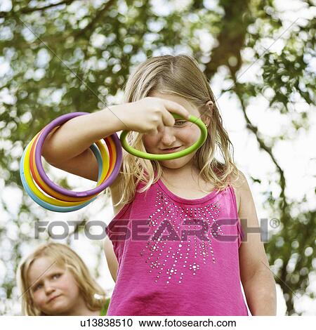 Stock Image - Girl throwing rings outdoors. Fotosearch