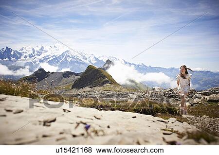Stock Photo - Girl walking in rocky landscape. Fotosearch