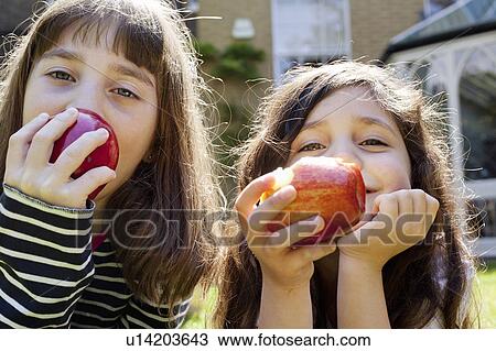 Girls eating apples outdoors View Large Photo Image Stock Image - Girls eating apples outdoors. Fotosearch