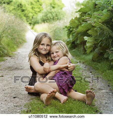 Girls hugging on dirt path View Large Photo Image Stock Image - Girls hugging on dirt path. Fotosearch