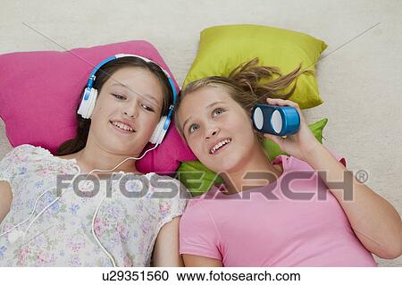 Stock Image - Girls listening to music together. Fotosearch