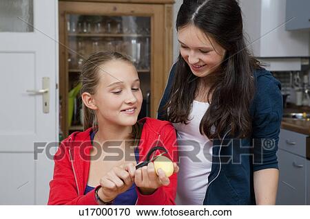 Girls peeling potatoes in kitchen View Large Photo Image Stock Image - Girls peeling potatoes in kitchen. Fotosearch