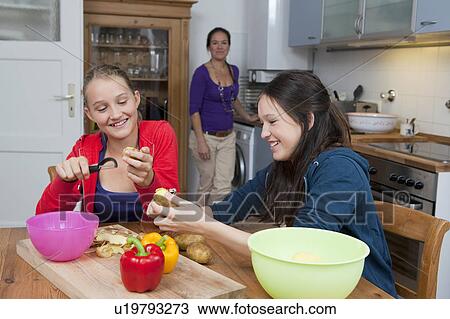 Girls peeling vegetables in kitchen View Large Photo Image Stock Image - Girls peeling vegetables in kitchen. Fotosearch