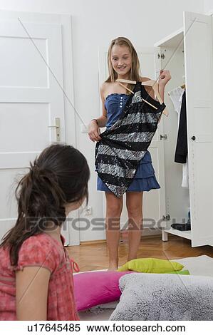 Girls picking outfits in bedroom View Large Photo Image Stock Photography - Girls picking outfits in bedroom. Fotosearch
