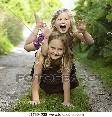 Girls playing together on dirt path View Large Photo Image Stock Photo - Girls playing together on dirt path. Fotosearch
