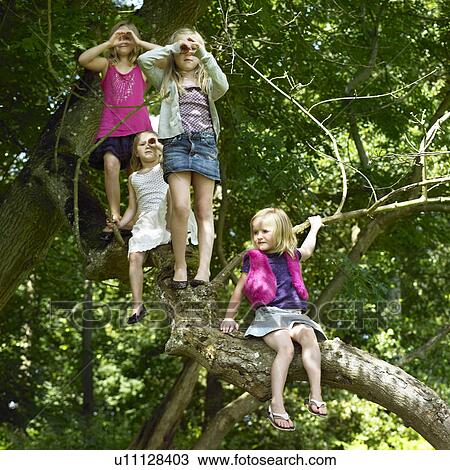 Stock Image - Girls playing with telescopes in tree. Fotosearch