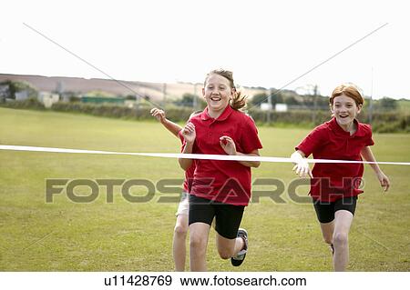 Stock Photo - Girls racing to cross finish line. Fotosearch