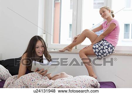 Stock Photo - Girls relaxing in bedroom. Fotosearch