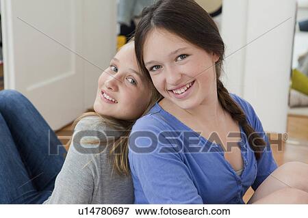Stock Photo - Girls sitting together in bedroom. Fotosearch