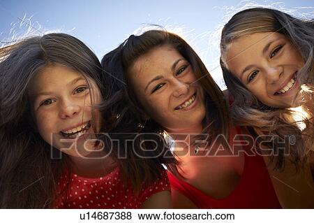 Girls smiling against blue sky View Large Photo Image Stock Photo - Girls smiling against blue sky. Fotosearch
