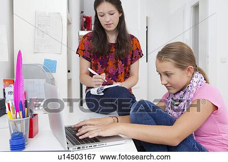 Girls studying with laptop at desk View Large Photo Image Stock Photo - Girls studying with laptop at desk. Fotosearch